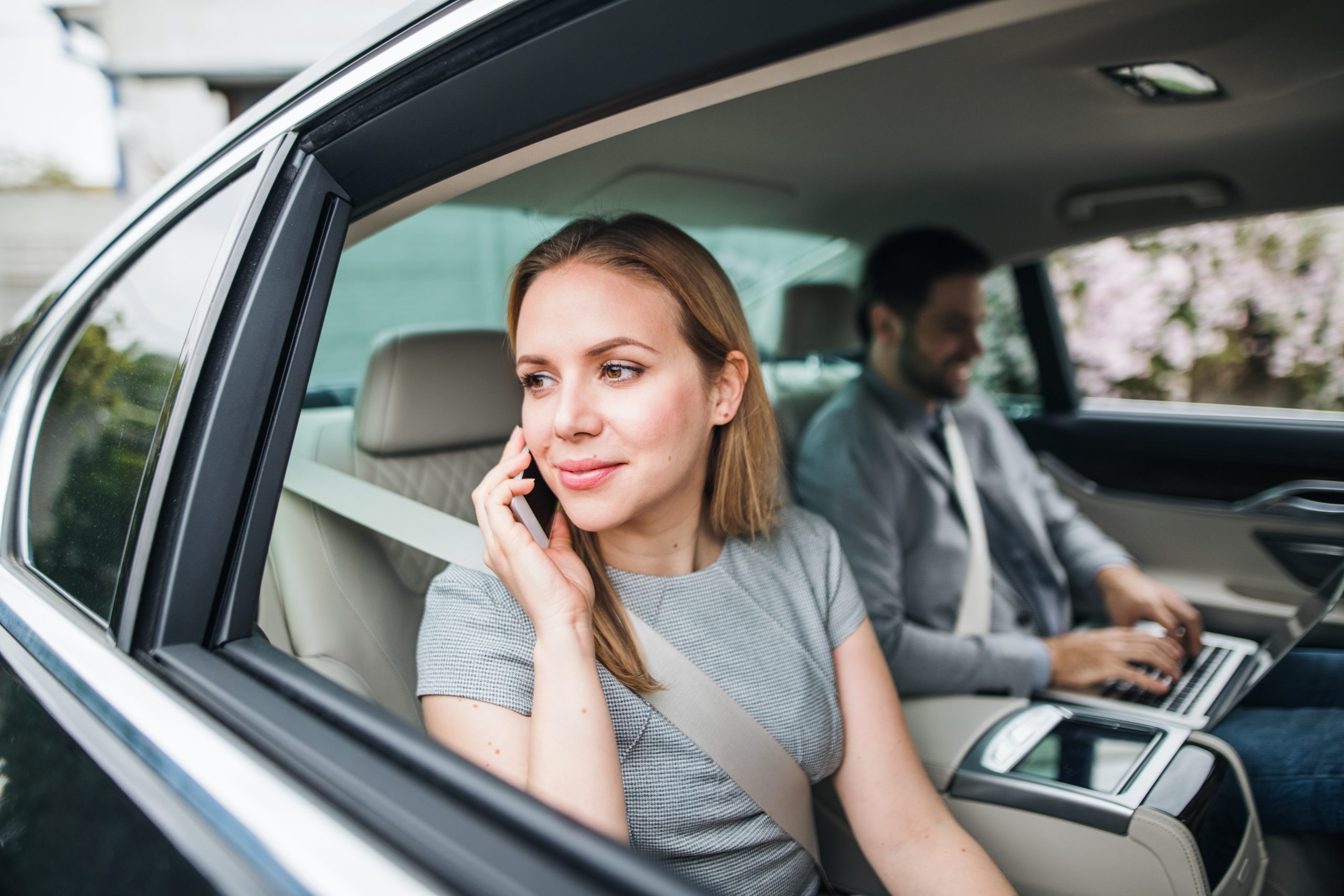 business-couple-with-laptop-sitting-on-back-seats