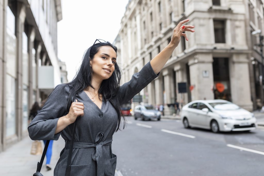 woman-in-the-city-hailing-a-taxi-london-uk